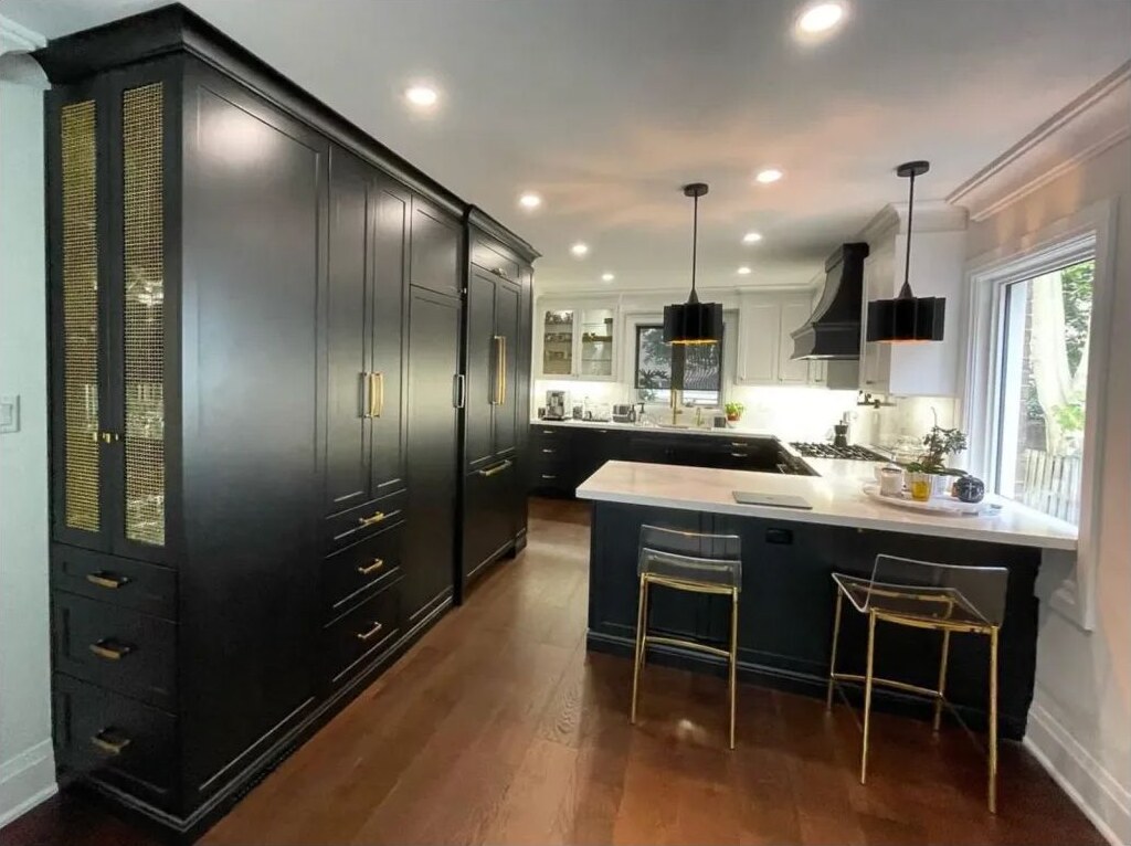 Black custom cabinetry, millwork, island and integrated lighting completed by Arima Kitchens